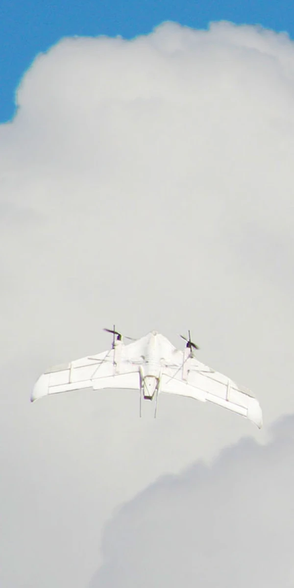 晴れた空と雲を背景に、ドローンが飛んでいる